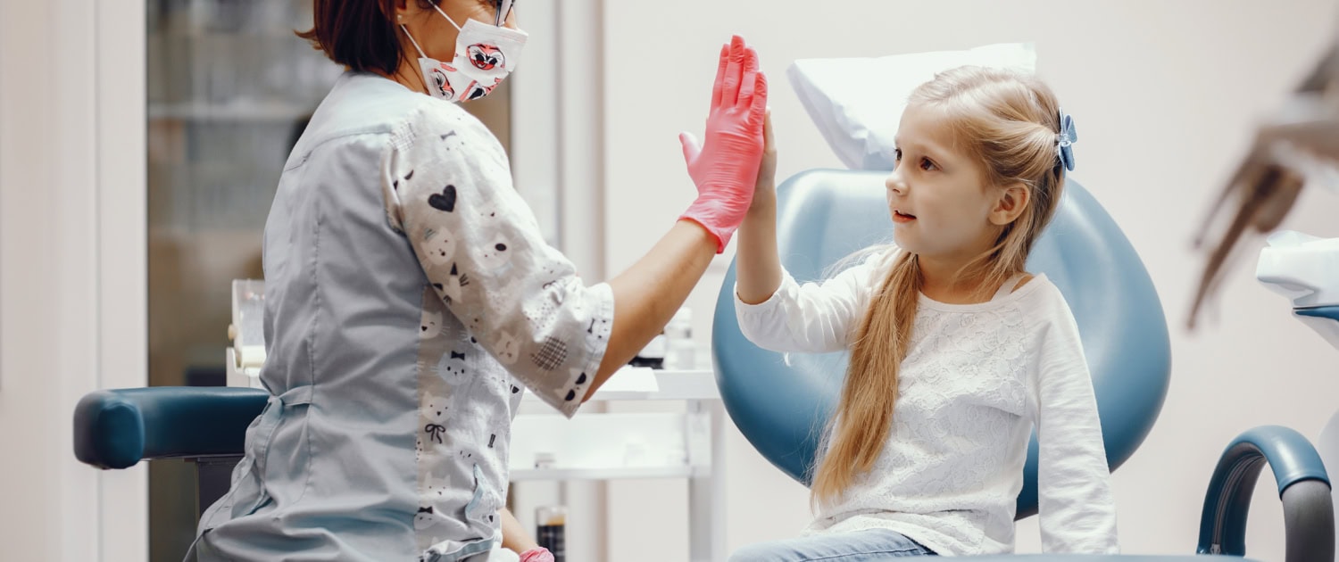 Cute little girl sitting in the dentist's office