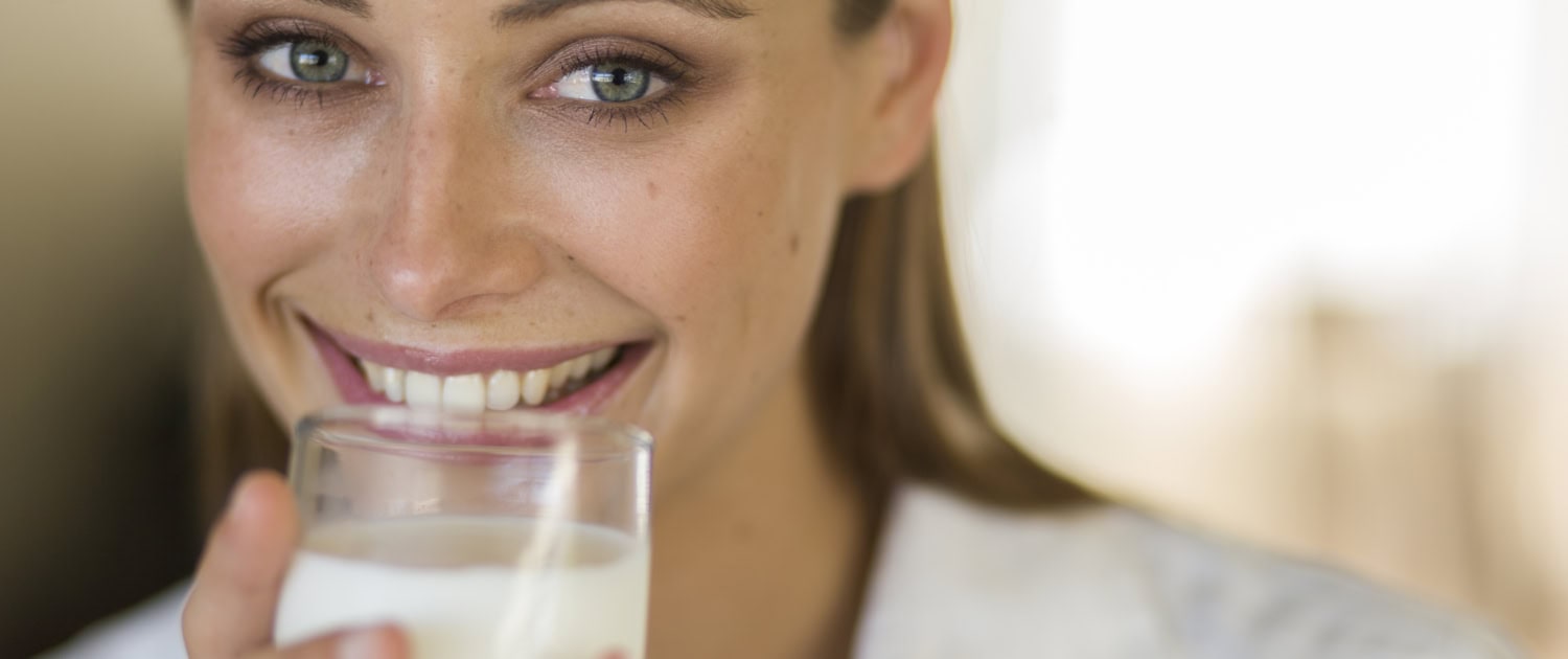 close-up-portrait-young-woman-drinking-milk-home