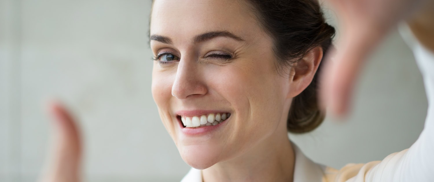 Closeup of Smiling Woman Making Frame Gesture
