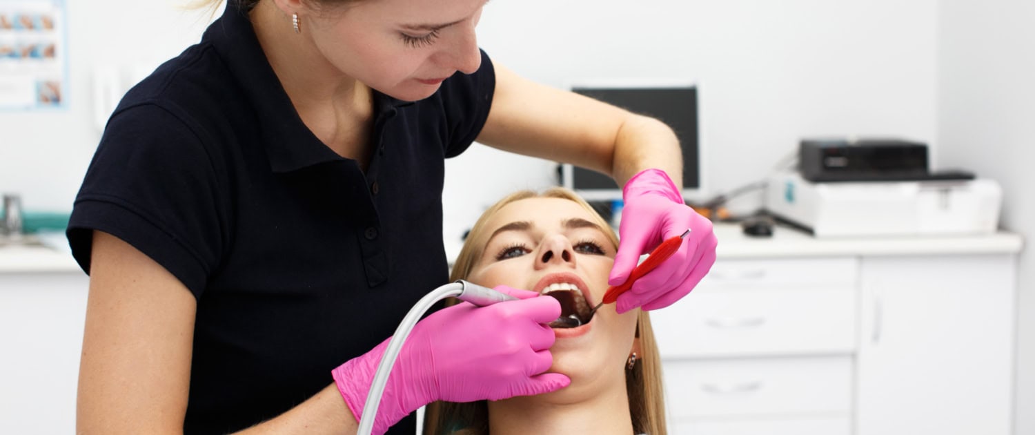 Female dentist treating her patient teeth