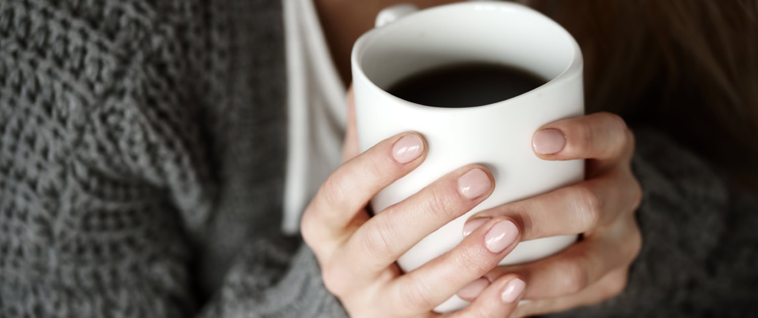Human hand holding coffee mug
