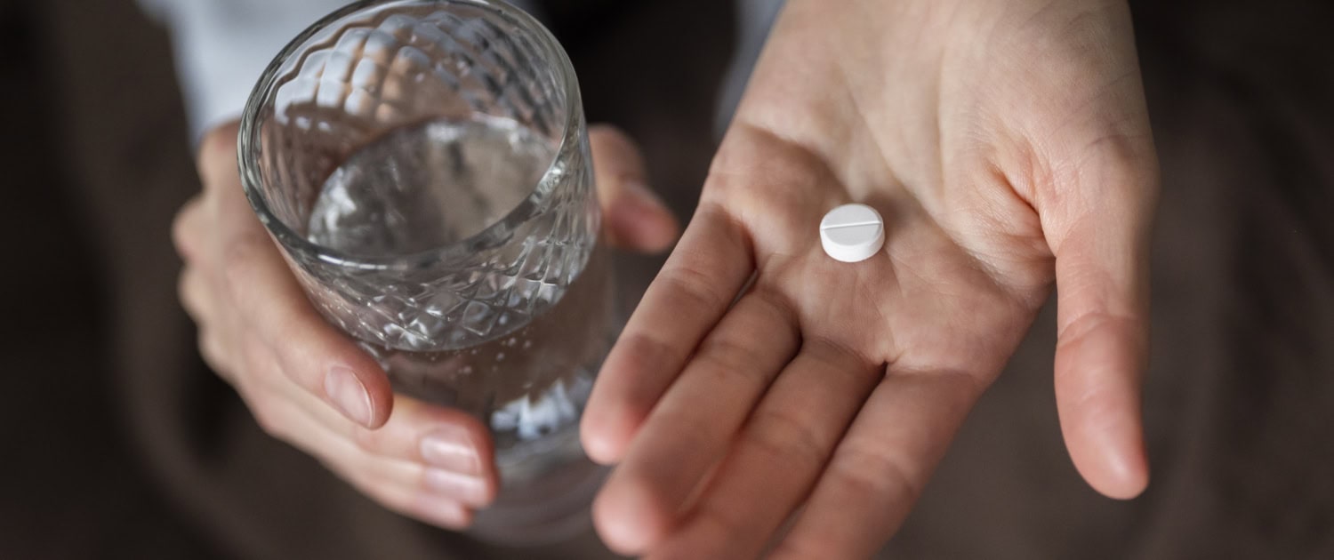 close-up-hands-holding-pill-glass