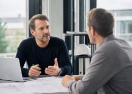 Konzultácia s dodávateľom bezpečnostno technickej služby pri stole s dokumentáciou